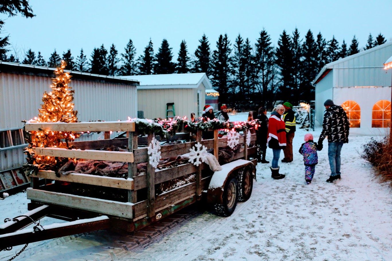 Families gathering at the Christmas wagon, decorated with a lit tree and snowflakes